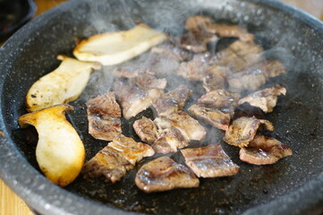 불판 위에서 삼겹살을 맛있게 굽고 있는 모습