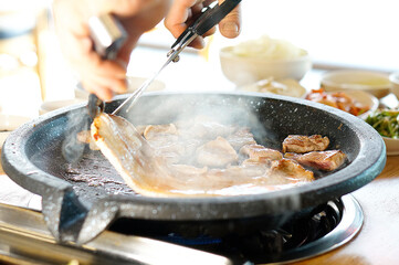 불판 위에서 삼겹살을 맛있게 굽고 있는 모습