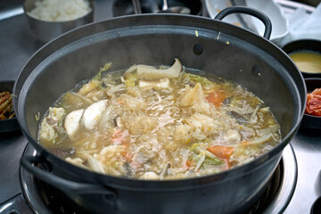 식탁 위에서 만두 전골을 맛있게 끊이고 있는 모습