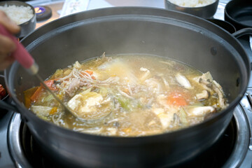 식탁 위에서 만두 전골을 맛있게 끊이고 있는 모습