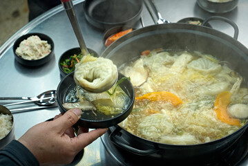 식탁 위에서 만둣국을 맛있게 끊이고 있는 모습