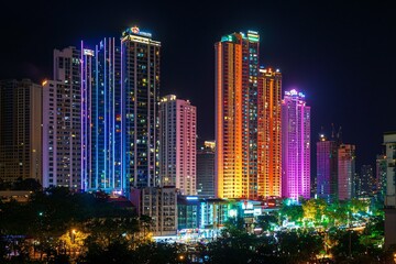Fototapeta premium Bright city lights at night bring to life a bustling metropolis, with colorful skyscrapers radiating energy and excitement throughout the urban landscape.
