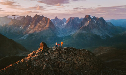 Aerial view in Norway - family travel climbing mountains mother, father, and child on summit together adventure trip parents and kid on active vacations tour outdoor in Lyngen Alps sunset landscape