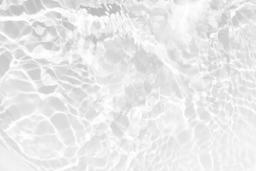 White water with ripples on the surface. Defocus blurred transparent white colored clear calm water surface texture with splashes and bubbles. Water waves with shining pattern texture background.