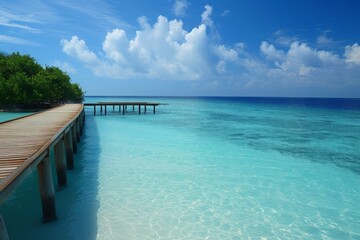 Fototapeta premium A serene view of turquoise waters and wooden walkways at a Maldivian island during a bright day in paradise