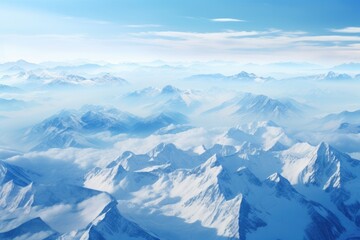 Obraz premium Aerial view of a majestic snow-covered mountain range under a clear blue sky, showcasing the beauty of nature in wintertime at high altitudes