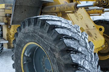 雪のついた重機のタイヤ