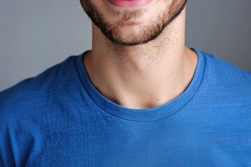 Fototapeta premium Close up portrait of smiling handsome guy in blue t shirt isolated on gray background