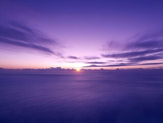 Fototapeta premium Purple Sunset Paints the Calm Ocean with Dreamy Hues and Wispy Clouds Gracefully Adorn the Sky