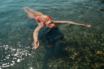 Happy woman sea relaxing floating in transparent sea water on summer holiday. Travel leisure...