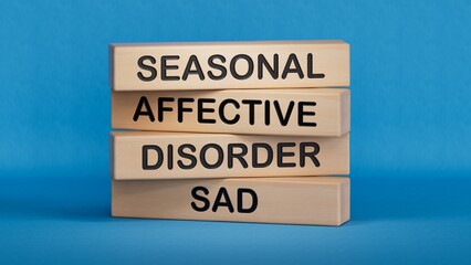 Sad - Seasonal Affective Disorder symbol. Wooden blocks with words Sad.Business and Sad concept. Wooden cube blocks. Copy space.3D rendering on blue background.
