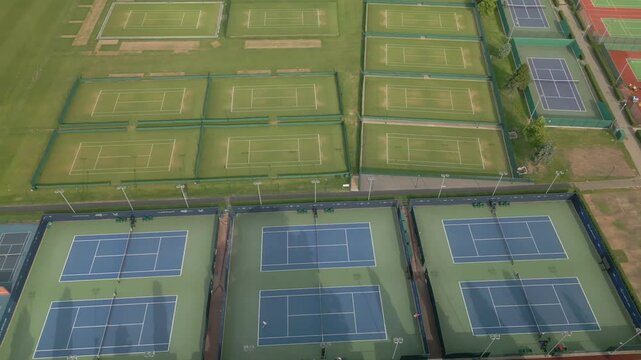Drone shot grass and hard surface tennis courts at sports centre