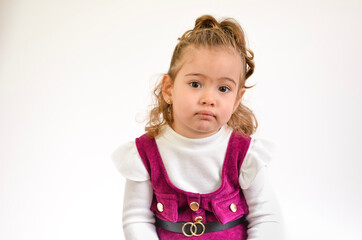 Portrait of cute toddler girl showing neutral emotion on white background