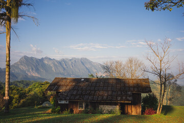 landscape and travel concept with sunlight and cloudy sky with country house on mountain