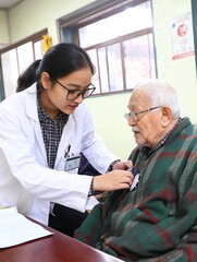 Obraz premium A healthcare professional checks the vitals of an elderly patient in a caring environment.