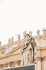 Marble statue of an apostle in front of a grand classical facade
