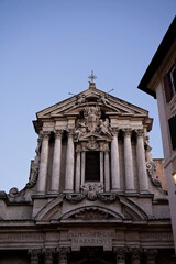 A baroque church facade against an evening sky backdrop