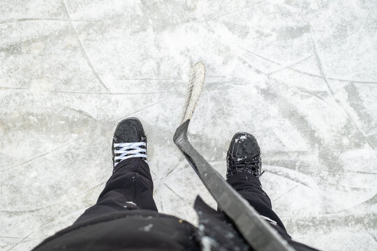View from Above: Ice Skates and Hockey Stick on Frozen Rink