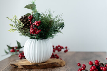 Elegant winter floral arrangement with holly berries and pinecones