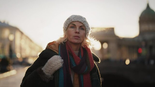 Beautiful aged townswoman walking and resting in downtown in winter holiday. Female tourist enjoying beauty of old city, local tourism and sightseeing, medium portrait, slow motion, lady city dweller