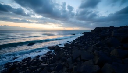 Obraz premium a rocky beach next to the ocean under a cloudy sky