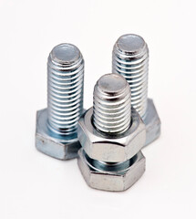 Three metallic bolts and nuts arranged in a triangular formation on a white background