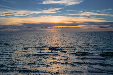 Sea sunset with cloudy sky and sun through the clouds over. Clouds Ocean and sky background, seascape.