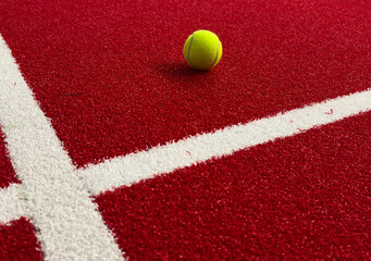  paddle tennis balls near the lines of a red paddle tennis court, racket sports concept