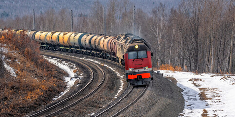 Cargo transportation industry. Tanks with oil and gasoline. Freight train on a railway curve.
