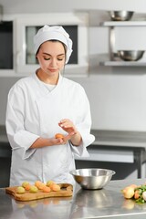 Cooking concept. A professional woman cook works in a restaurant kitchen