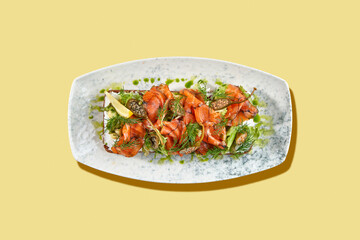 A vibrant and refreshing smorrebrod, a traditional Danish open-faced sandwich, topped with smoked salmon, fresh vegetables, herbs, and a creamy spread
