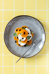 A plate of delicious Caprese salad with yellow tomatoes and mozzarella, balsamic vinegar, top view