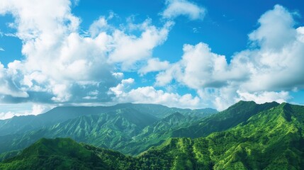 Obraz premium Beautiful panoramic view of lush green mountains and soft clouds.