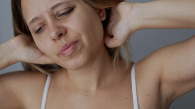 Young blonde woman scratching the head with her hands on dark gray background. Dry skin, severe allergy, eczema, psoriasis, lack of vitamins, erythema, itch, itching, peeling, seborrheic dermatitis