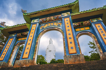 Beautiful Gate of Linh ung Pagoda and White Lady Buddha with blue sky at Chua Linh Ung Bai But Temple, Da Nang, Vietnam.