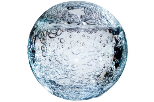 Clear spherical object filled with bubbles floating in water illuminated by soft light