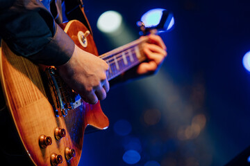 Obraz premium Guitarist Playing Under Dramatic Blue Stage Lighting