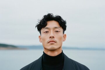 Peaceful Portrait of East Asian Man by Water in Soft, Natural Light