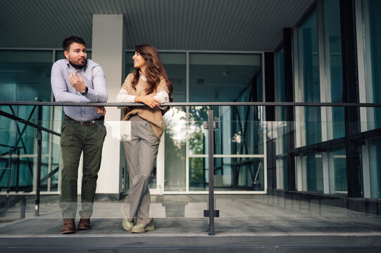 Business people having informal conversation on office building balcony