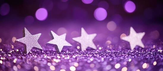 Purple glitter background with four silver stars arranged in a row showcasing bokeh effect and ample Copy Space for text placement
