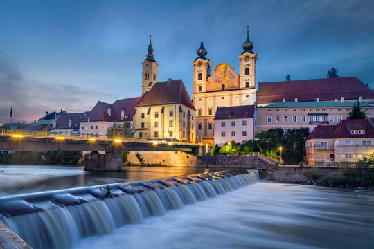 Steyr, Austria. Saint Michael church and bridge over Steyr river at dusk