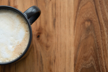 cropped shot of a cup of coffee on wood background