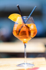 apperol spritz cocktail with a slice of orange and drinking straw