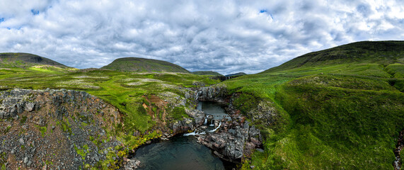 Panorama image of an icelandic river canyon shot in summer with overcast sky