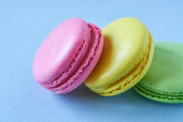 Colorful macaroons on blue background. Selective focus.