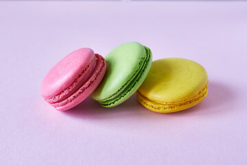 Colorful macaroons on pink background, close-up.