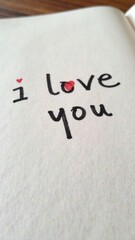 A handwritten inscription, the text "I love you" on a white sheet of paper, in a notebook or diary. A painted heart. A declaration of love. Romantic card for Valentine's Day, Mother's Day.