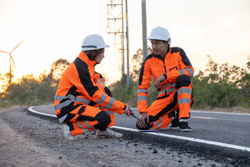Engineer worker wearing safety suite walking survey inspect new road build for final quality check