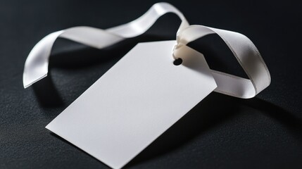 A simple, yet elegant white tag tied with a black ribbon on a matte black background