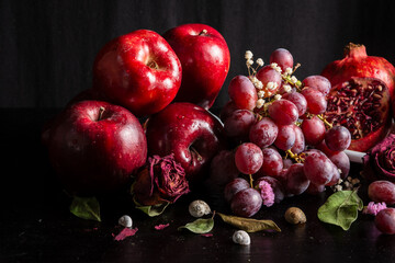 Close-up of apples, grapes, dried flowers and pomegranates on table in horizontal with copy space